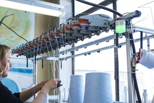 Female operator working at thread rewinding machine cropped view