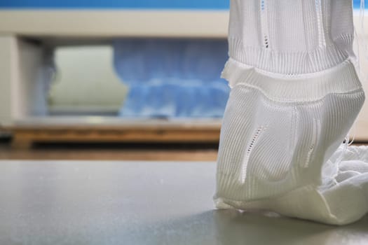Produced piece of white knitted fabric view at a knitting shop