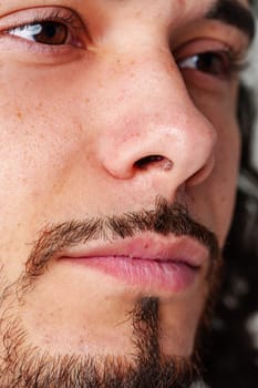 Close-up of a person's face subtle freckling, and facial details in soft studio lighting