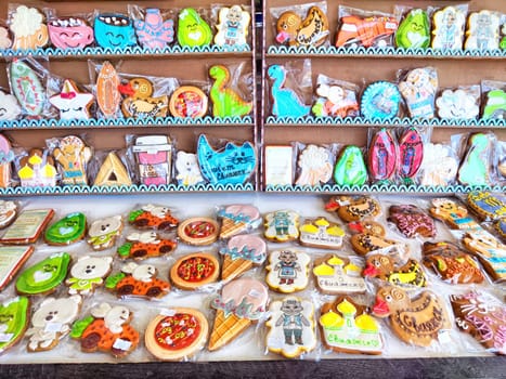 A variety of intricately designed cookies arranged neatly on shelves.