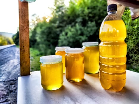 Various jars of honey showcase different colors and textures, capturing the richness of natural sweetness in a market setting.