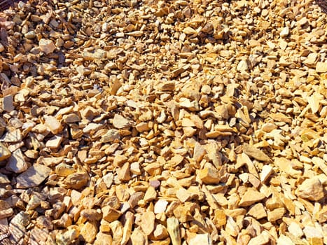 Small, colorful gravel stones cover the ground at a construction location under clear blue skies. background, texture, pattern, frame, place for text
