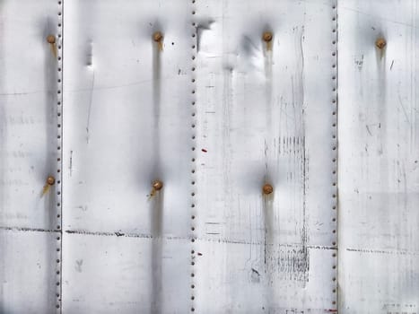 The surface features a textured metallic pattern with visible rivets arranged neatly, ideal for adding text or copy.