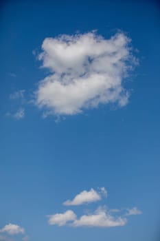 A calming view of fluffy white clouds drifting in a vivid blue sky, evoking a deep sense of tranquility