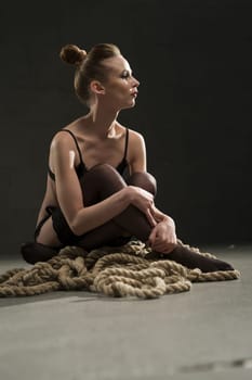 Beautiful woman in black underwear sitting on the floor portrait