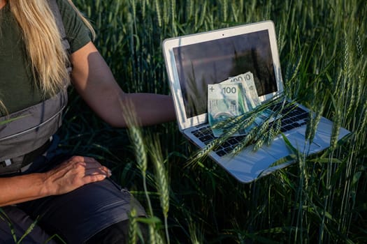 A farmer using a laptop in a lush green field, showcasing the blend of agriculture and modern technology