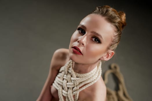 Beautiful woman in the nude tied up with rope high angle portrait