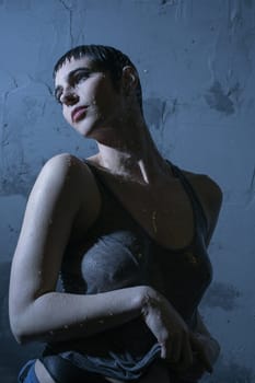 Brunette in sexy wet t-shirt in dark room profile portrait
