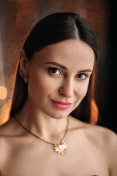Beautiful elegant woman in black dress with festive makeup, beautiful photo with bokeh background.