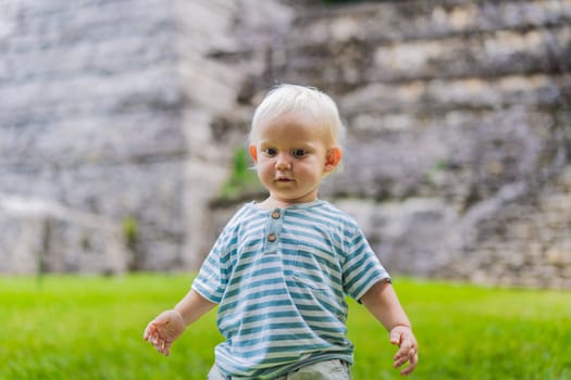 Baby tourist exploring the ancient pyramids of Palenque, Mexico, surrounded by dense jungle. Cultural heritage and adventure travel concept.
