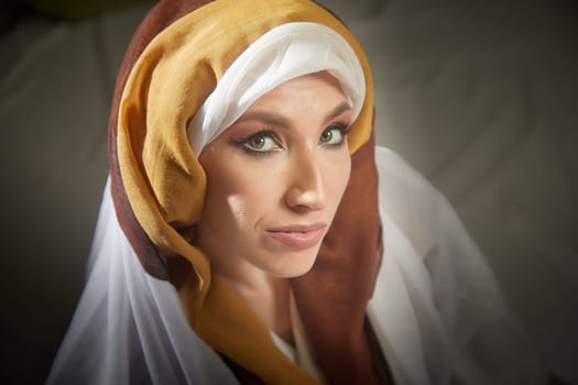 A girl poses in vibrant eastern national clothing, capturing the essence of Rebekah from the Christian Bible in a thoughtful manner.