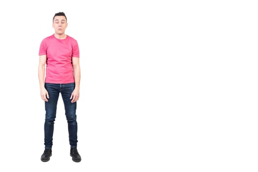 Full body of exhausted sleepy male model in casual clothes woken up early in morning in studio against white background