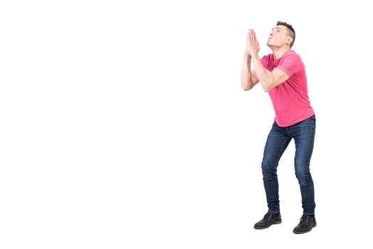 Full body of male with imploring expression begging with praying hands and hoping for help on white background