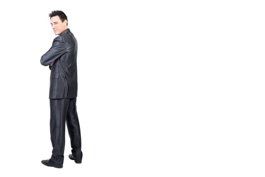 Full body of content male in formal suit looking over shoulder at camera with squinting eyes isolated on white background