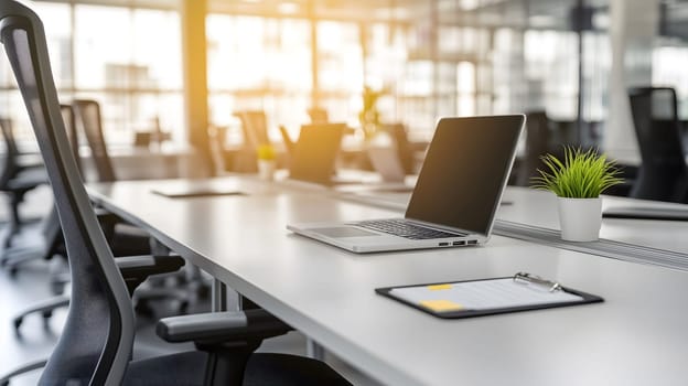 Laptop is sitting on a desk with a blank screen in an open plan office