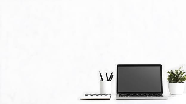 Clean and organized workspace is waiting for a productive day featuring a laptop, a notebook and a pen holder