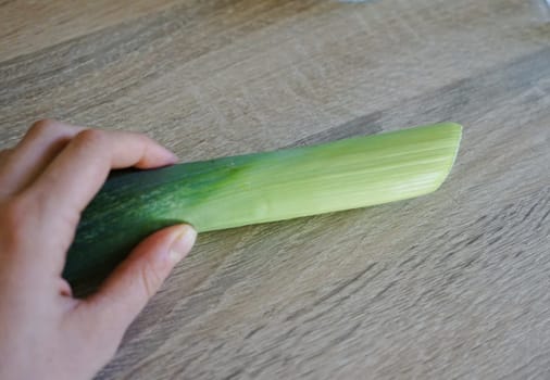 woman hand holds leek steam preparing vegetables cooking healthy nutritious fibre vitamin soup. High quality photo