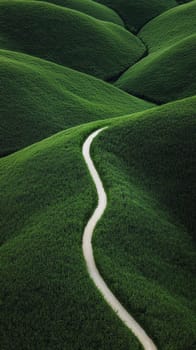Winding path through lush green hills. Concept of nature, tranquility, and exploration.