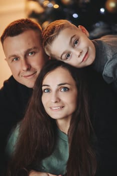 A family around the Christmas tree in the new year, a holiday with family,a beautiful happy stylish family.