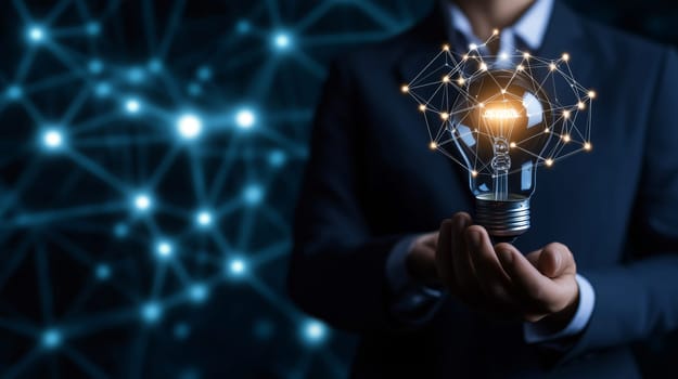 Businessman is holding an illuminated light bulb connected with a network, symbolizing innovation and new ideas