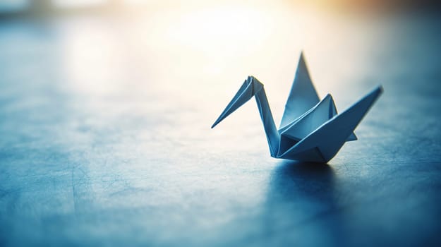 Single origami crane is standing on a blue surface with a bright backlight