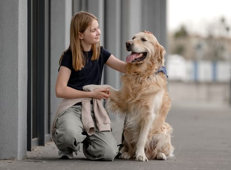 Girl With Golden Retriever Sits Playing Outside
