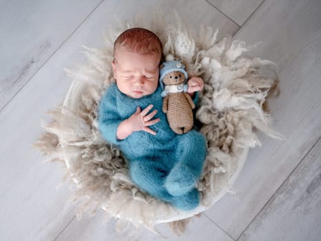 Newborn Baby Sleeps In Fur With Teddy Bear Toy During Photoshoot