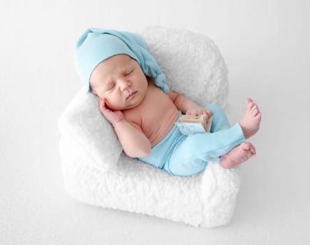 Newborn Baby Sleeps In Chair During Photo Session