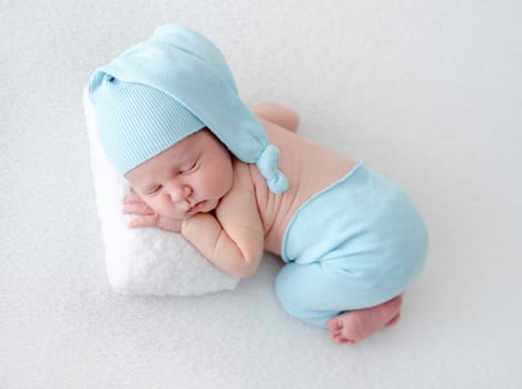 Newborn Baby Sleeps On Pillow During Photo Session