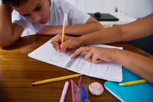 A young student receives personalized math tutoring at home. Focused learning session with mentor and child practicing calculations together. Educational support and academic development.