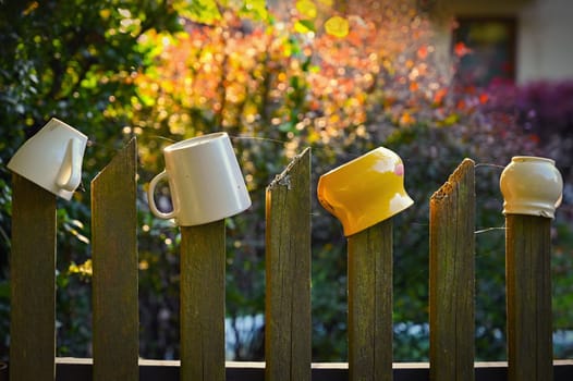 Mugs on the fence. Autumn background with nature and sunset.
