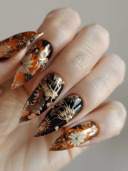 A closeup of a persons fingers with a floral design created using gold nail polish. This exquisite manicure showcases intricate nail art on artificial nails
