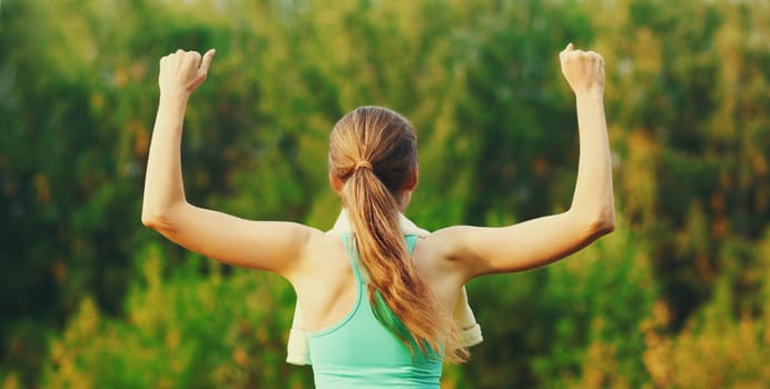 Fitness happy strong woman enjoying after training outdoors, runner winner in summer park
