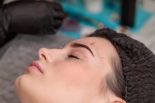 Beautician using caliper to measure eyebrows before microblading treatment