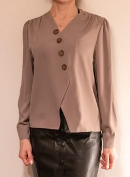 Skinny woman wearing stylish leather tight skirt and warm tone blouse