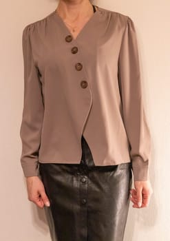 Skinny woman wearing stylish leather tight skirt and warm tone blouse
