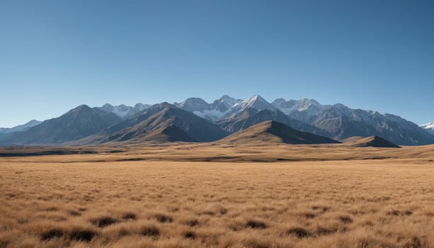 A tranquil landscape reveals rolling golden grasslands contrasting with majestic mountain peaks under a brilliant blue sky, evoking a sense of peace and solitude.