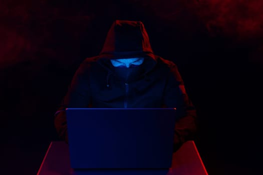 Computer Hacker in Hoodie. Obscured Dark Face. Hacker Attack, Virus Infected Software, Dark Web and Cyber Security Concept .