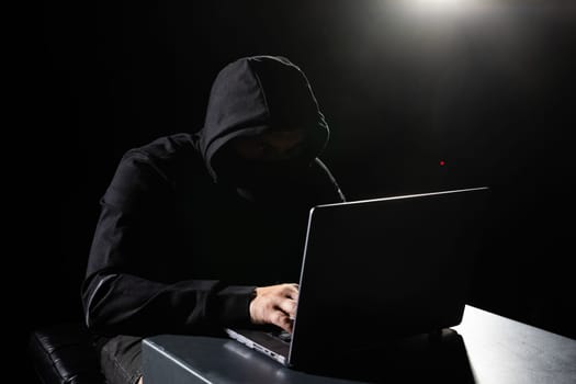 Computer Hacker in Hoodie. Obscured Dark Face. Hacker Attack, Virus Infected Software, Dark Web and Cyber Security Concept .