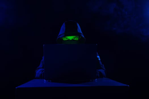 Computer Hacker in Hoodie. Obscured Dark Face. Hacker Attack, Virus Infected Software, Dark Web and Cyber Security Concept .