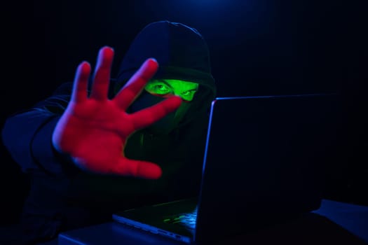 Computer Hacker in Hoodie. Obscured Dark Face. Hacker Attack, Virus Infected Software, Dark Web and Cyber Security Concept .