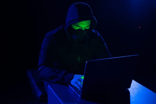 Hackers wear hoods to cover their faces. Hacking to steal important information. Use a computer to release malware viruses Ransom and harass organizations. He sitting in the dark room with neon light