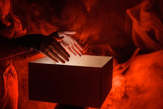 female hands reaching into magic box in red smoke, surprise concept,