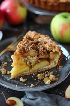 A slice of delicious apple crumble pie with fresh apples in the background