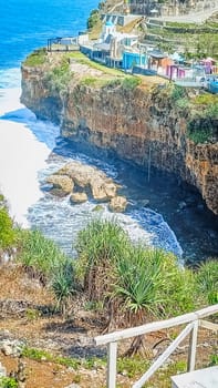 Stunning view of a rocky cliff overlooking the vast, blue ocean with waves crashing below. The harmonious blend of sea and sky offers a sense of peace and tranquility.