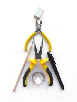 Creative flat lay of yellow hand tools and office supplies on white background.