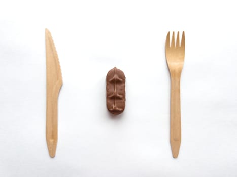 Minimalist composition with wooden cutlery and chocolate.