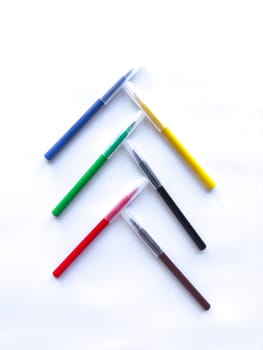 Colorful pen arrangement on white background in geometric pattern.