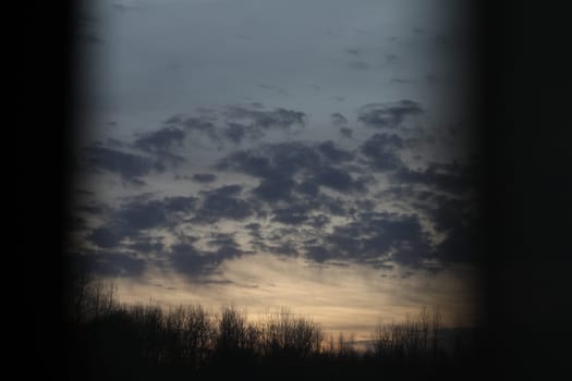 Sunset clouds mirrored in the window. Nature sunset sky backdrop. Blurry abstract sunrise background.