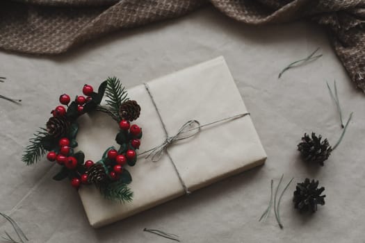 Christmas composition. Gift, fir tree branches, balls on craft paper background. Christmas, winter, new year concept. Flat lay, top view, copy space.